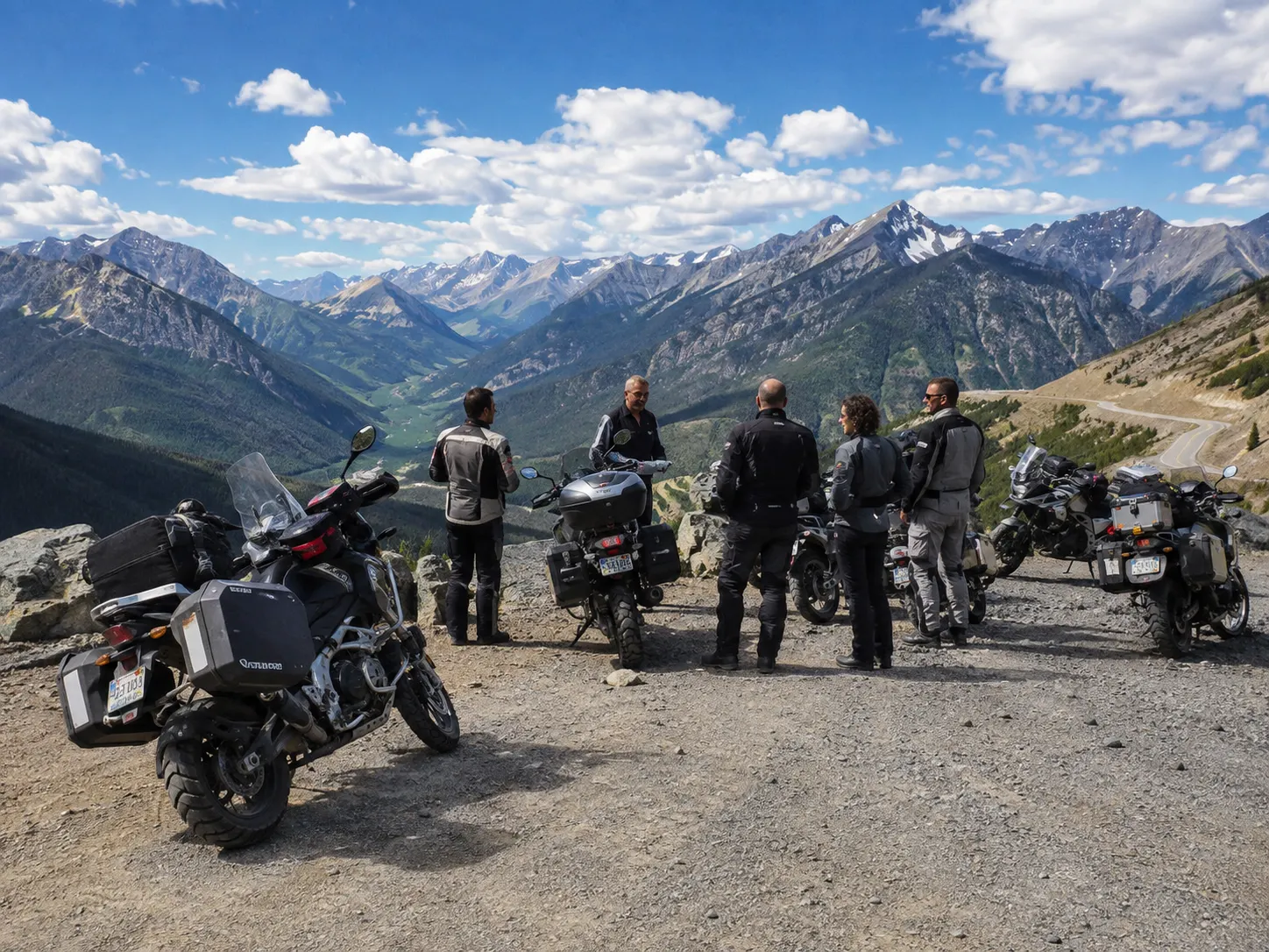 Grupo de motoristas en una pista de tierra en un paisaje de alta montaña